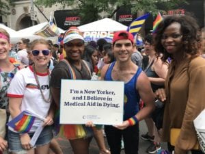 New York Pride event with supporters holding a sign saying "I'm a New Yorker and I believe in Medical Aid in Dying in 2019